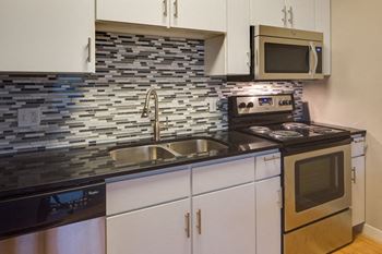 Stainless steel applicances with built-in microwave and white wood cabinets